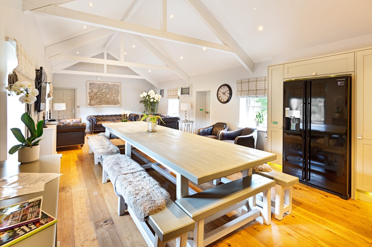 A long dining table in a bright room with a vaulted ceiling